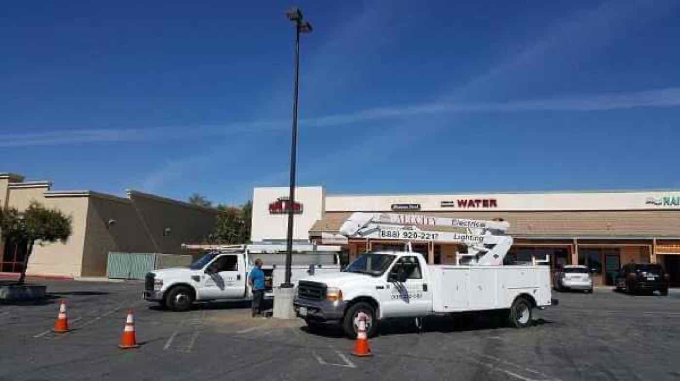 A bucket truck at a shopping center parking lot.